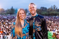 a man and woman posing for a photo in front of a crowd